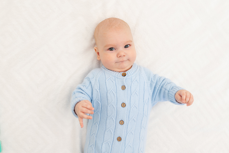 portrait of a serious baby boy on the bed before going to bed or the morning of the baby